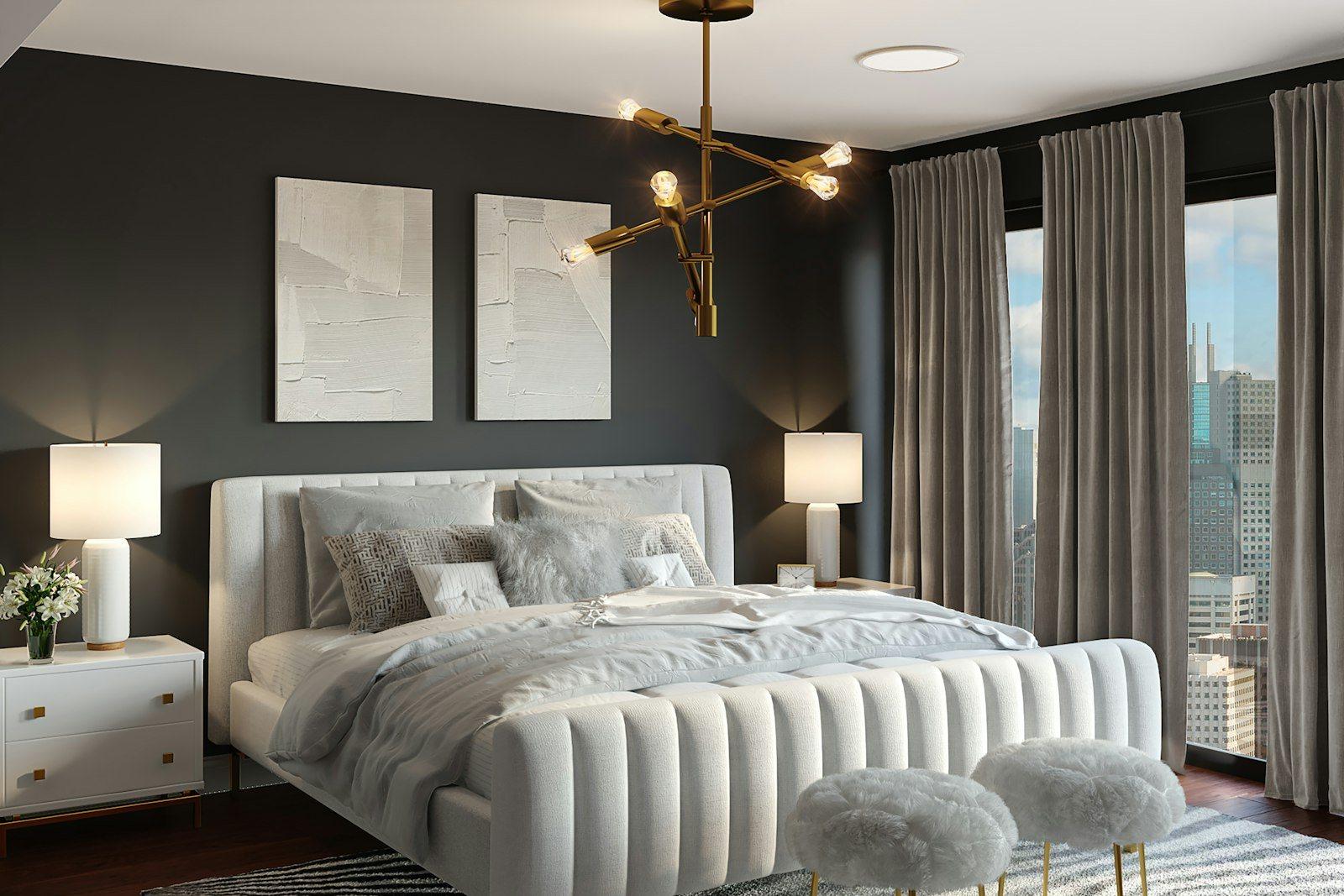 Principal bedroom with a charcoal wall, brass sputnik chandelier, a channel-tufted bed with upholstered stools at its foot and the city visible through the window alongside.