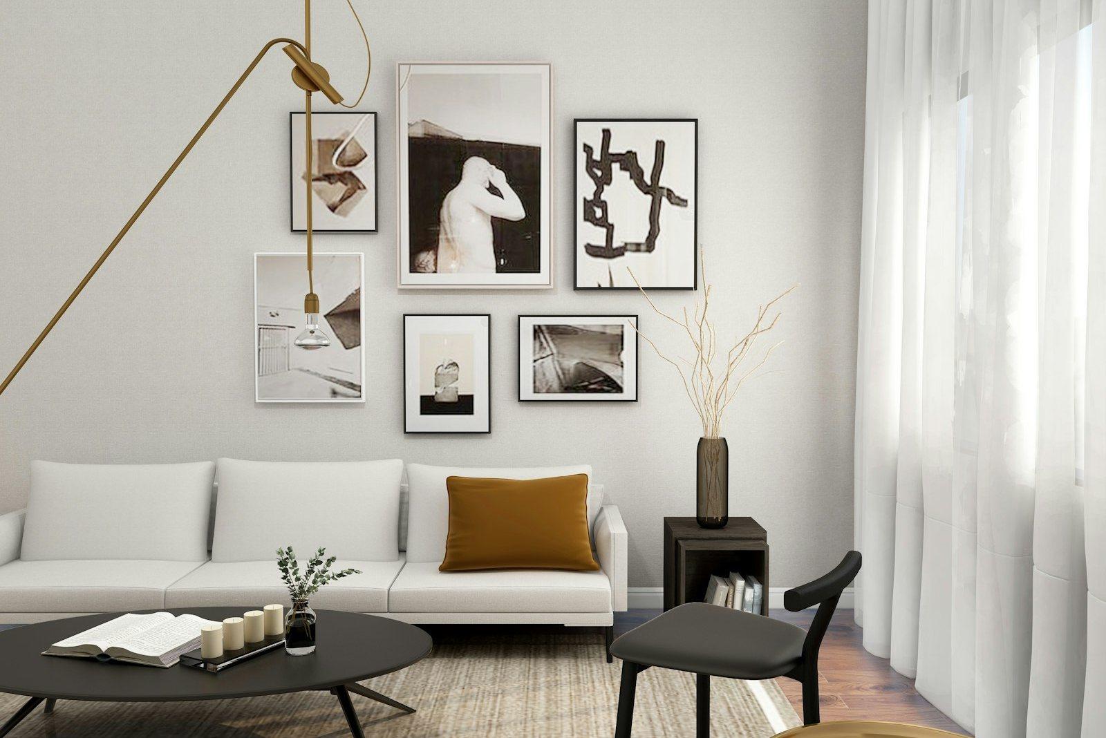 Reception room with a low white sofa, a slim brass swing-arm pendant, a hung group of framed monochrome prints and full-height sheer curtains along one wall.
